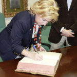 La Consejera de Educación, Dolores Serrat, firmando en el libro de Honor de la Fundación La Caridad
